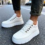 White suede lace-up sneakers with platform sole, front side view on pavement.